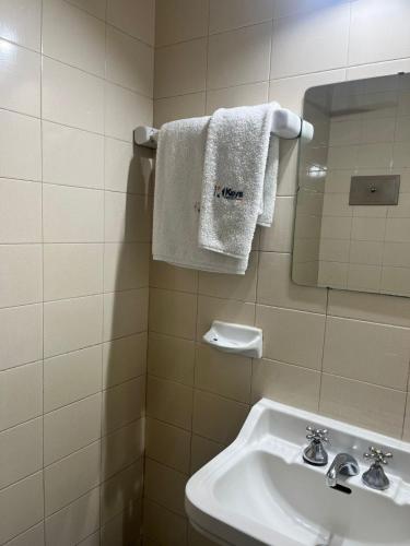 a bathroom with a sink and a mirror and a towel at Hotel KEY´S in Buenos Aires