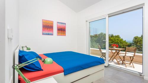 a bedroom with a bed and a balcony with a table at Casa Tijana by Villas Guide in Krk