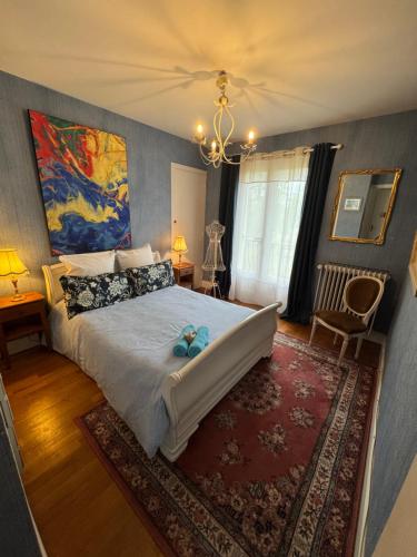 a bedroom with a large bed with a blue teddy bear on it at Le Relais St trop - Villa 2 chambres Delon et Romy in Bressolles