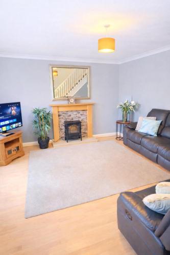 a living room with a couch and a fireplace at Bedlington 3 bed house in Bedlington