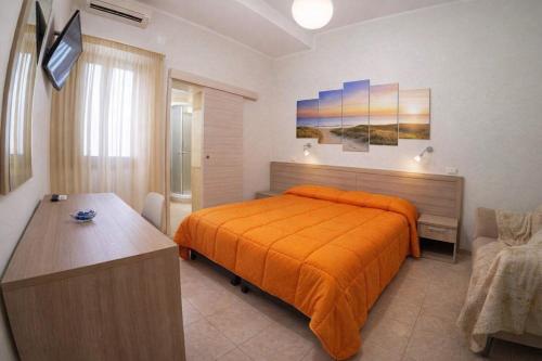 a bedroom with a bed with an orange bedspread at Villa Merina in Vieste