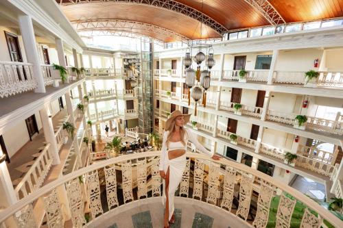 a woman in a white dress walking in a building at The Taksim Royal Beachfront Resort in Patong Beach