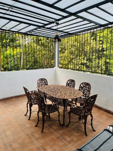 a patio with a table and chairs in front of windows at Yolcehuikalli - Loft Cuetzalan in Cuetzalán del Progreso