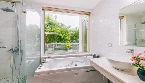a bathroom with a tub and a sink and a window at Villa nt 48 FLC Thanh Hoá in Sầm Sơn