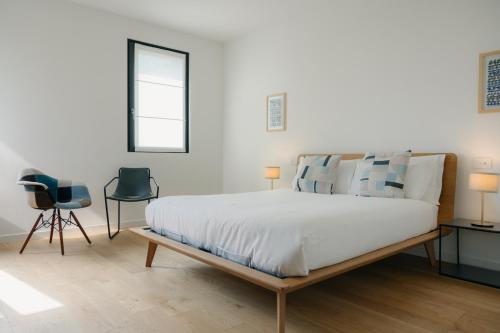 una camera da letto con un grande letto e due sedie di Stilla Rooms & Contemporary Cuisine a Colognola ai Colli