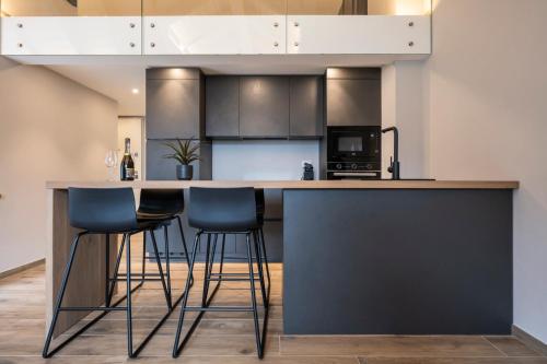 a kitchen with a large counter with stools at Ariel Penthouse - In the heart of Domodossola in Domodossola