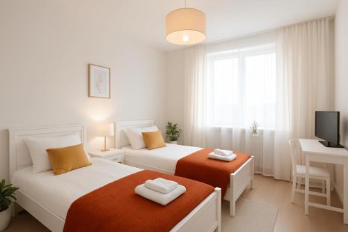 two beds in a room with a television and a desk at Hannover Group Apartment in Hannover