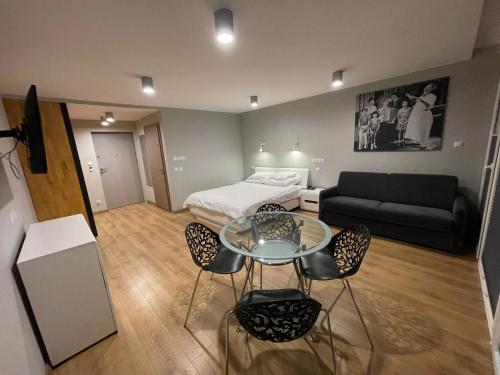 a living room with a bed and a table and chairs at Słoneczna DWÓJKA Resort SPA in Gródek Nad Dunajcem