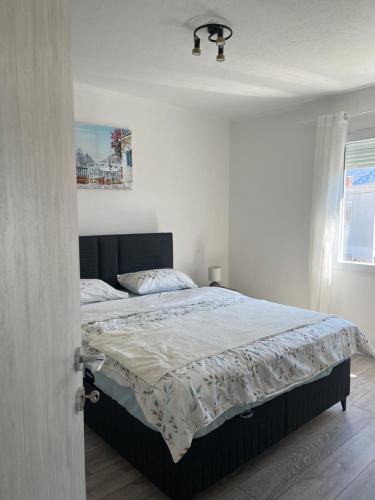 a bedroom with a bed in a white room at Apartment White Rose in Bar
