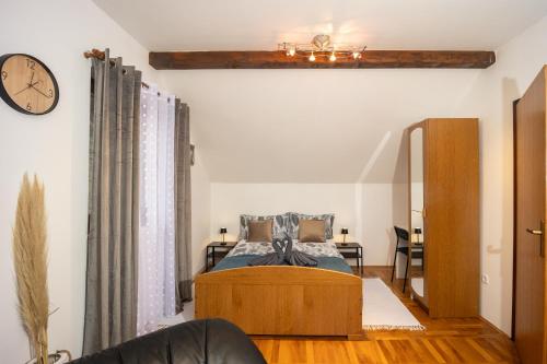 a bedroom with a bed and a clock on the wall at Vacation house Terra in Petrovina