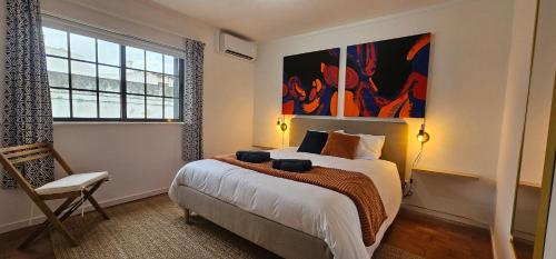 a bedroom with a bed and a painting on the wall at "Toca do Coelho" Charming Retreat close to Albufeira Beaches in Albufeira