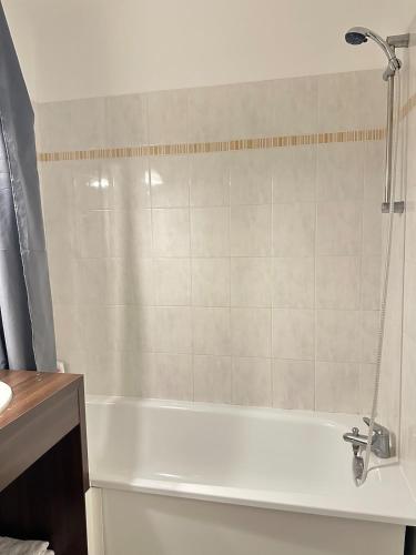 a bathroom with a bath tub with a shower at Charme et confort in Montévrain
