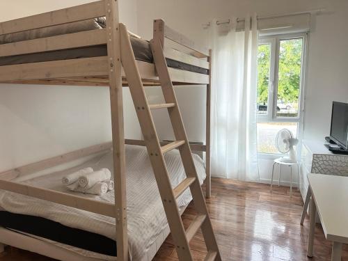 a bedroom with two bunk beds and a desk at Charme et confort in Montévrain