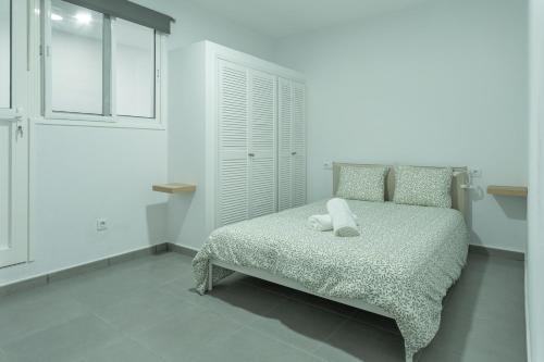 a white bedroom with a bed and a window at Vivienda Vacacional Tinisagua 3 in Breña Alta
