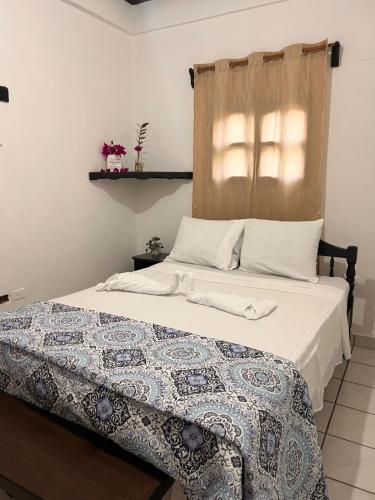 a bedroom with a bed with a quilt on it at Guest House Don Moisés in Copán Ruinas