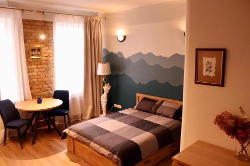 a bedroom with a bed with a mountain mural on the wall at Cozy Alauksta apartment in Riga