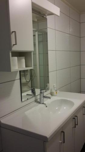 bagno con lavandino bianco e specchio di Bodø Apartment a Bodø