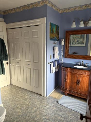 a bathroom with a white door and a sink at Bentley House Bed and Breakfast in Poultney