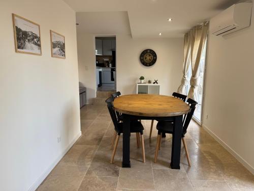 a kitchen and dining room with a wooden table and chairs at Maison 4 personnes in Saint-Julien