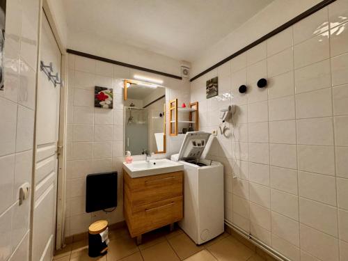 a small bathroom with a sink and a refrigerator at Charmant logement de plain-pied avec Piscine in Loudenvielle