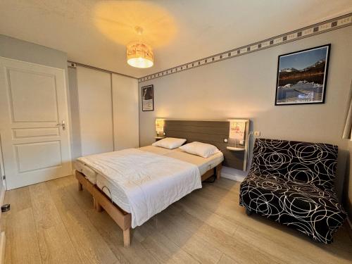 a bedroom with a bed and a chair in it at Charmant logement de plain-pied avec Piscine in Loudenvielle