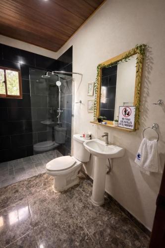 a bathroom with a toilet and a sink and a shower at Villa azul círculo auto in Jarabacoa