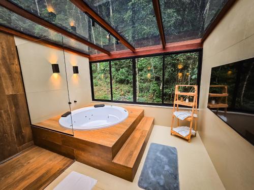 a bathroom with a tub in a room with windows at Pousada Conde Redondo in Lumiar