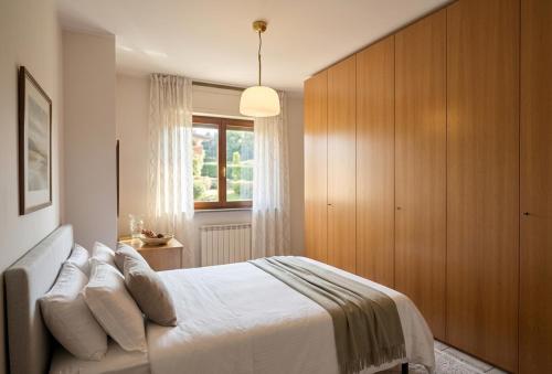 a bedroom with a bed and a large wooden cabinet at a casa di BIRI in Trezzo sullʼAdda