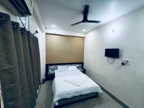 a bedroom with a bed and a ceiling fan at Hotel Sundaram in Deoghar