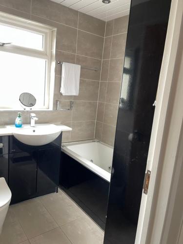 a bathroom with a sink and a bath tub and a toilet at Selsey Home in Selsey