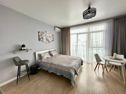a bedroom with a bed and a table and chairs at Ocean Grace Residence in Batumi