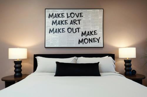 a bedroom with a bed with two lamps and a poster at 3BR & 3BA Downtown Modern Artsy Home Fully Equipped with Patio in Tampa