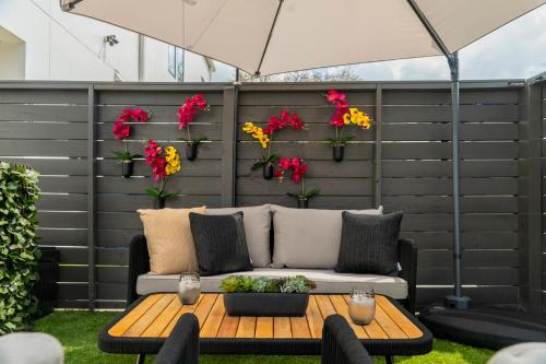 a patio with a couch and flowers on a wall at 3BR & 3BA Downtown Modern Artsy Home Fully Equipped with Patio in Tampa