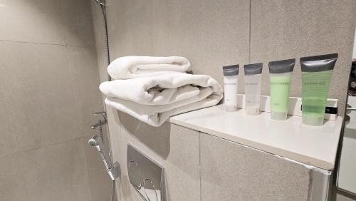 a bathroom with towels and products on a shelf at Solo Realty Apartments at Address Residence Fujairah in Sharm
