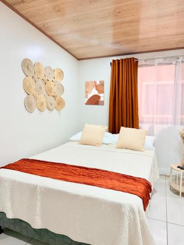 a bedroom with a bed with white sheets and a window at Apartamento #10 in Alajuela