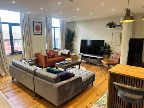a living room with a couch and a television at STUNNING Loft Apartments in Jarrow, South Tyneside in East Howdon