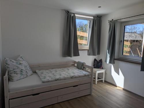 a bedroom with a bed and two windows at Brunner Alm in Obertaufkirchen