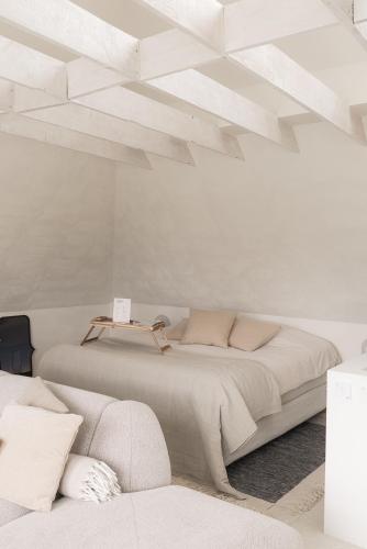 a white bedroom with a large bed and a couch at CODAK suite in Kluisbergen