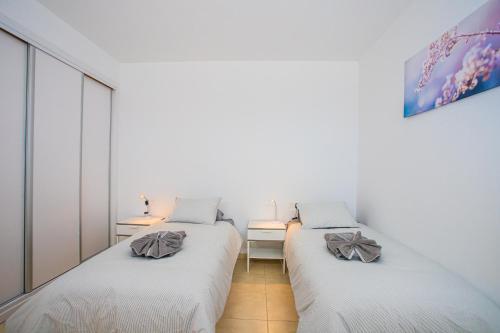 two beds in a room with white walls at Villa Amana 5 star luxury resort for 10 people in Playa Blanca in Playa Blanca
