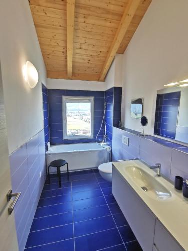 a blue bathroom with a tub and a sink at Ca Mea - Lake View, Parking, EV in Gordola