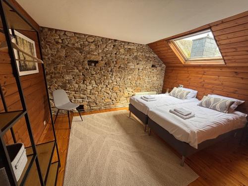 a bedroom with a bed and a stone wall at B&B Les Soigneurs in Grandmenil