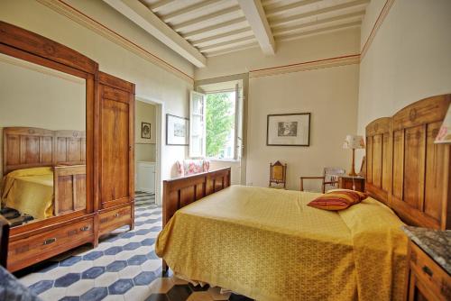 a bedroom with a large bed and a mirror at Villa Fiamma by PosarelliVillas in Piaggiori