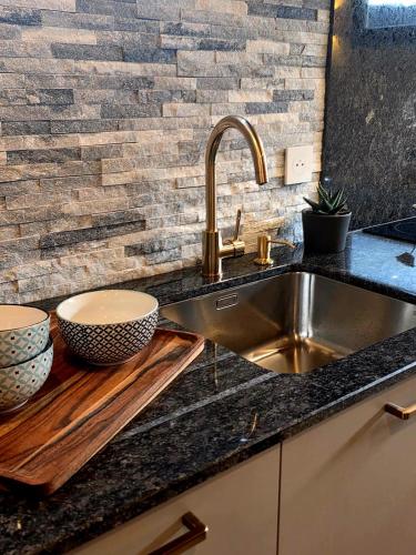a kitchen sink with two bowls on a wooden cutting board at Tiny House Annecy in Annecy