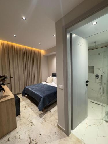 a bedroom with a bed and a glass shower at Alesia's Guesthouse in Vlorë