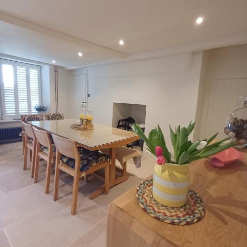 a dining room with a table and a potted plant at The Homestead -Cosy Cottage for 2 in Wells next the Sea