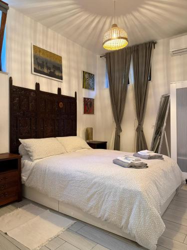 a bedroom with a large bed and a chandelier at La Casa di Ornella in Rome