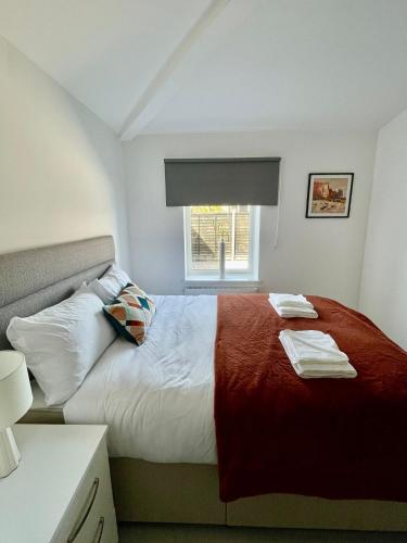 a bedroom with a red and white bed with a window at Ridgeways Premium House in Bristol
