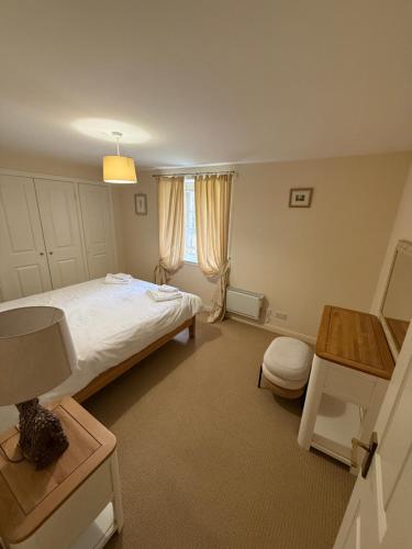 a bedroom with a bed and a table and a window at Culloden Stables 4 in Inverness
