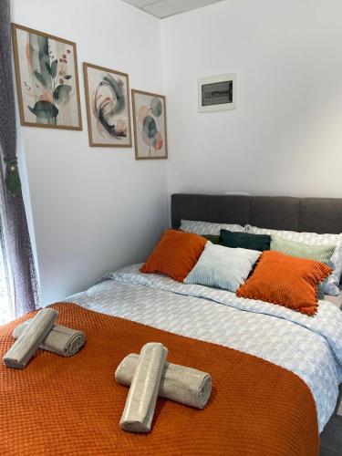 a bed with two pillows and an orange blanket at Studio Angelina in Prestranek