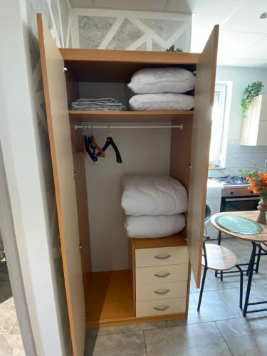 a cupboard with folded towels in a kitchen at Studio Angelina in Prestranek